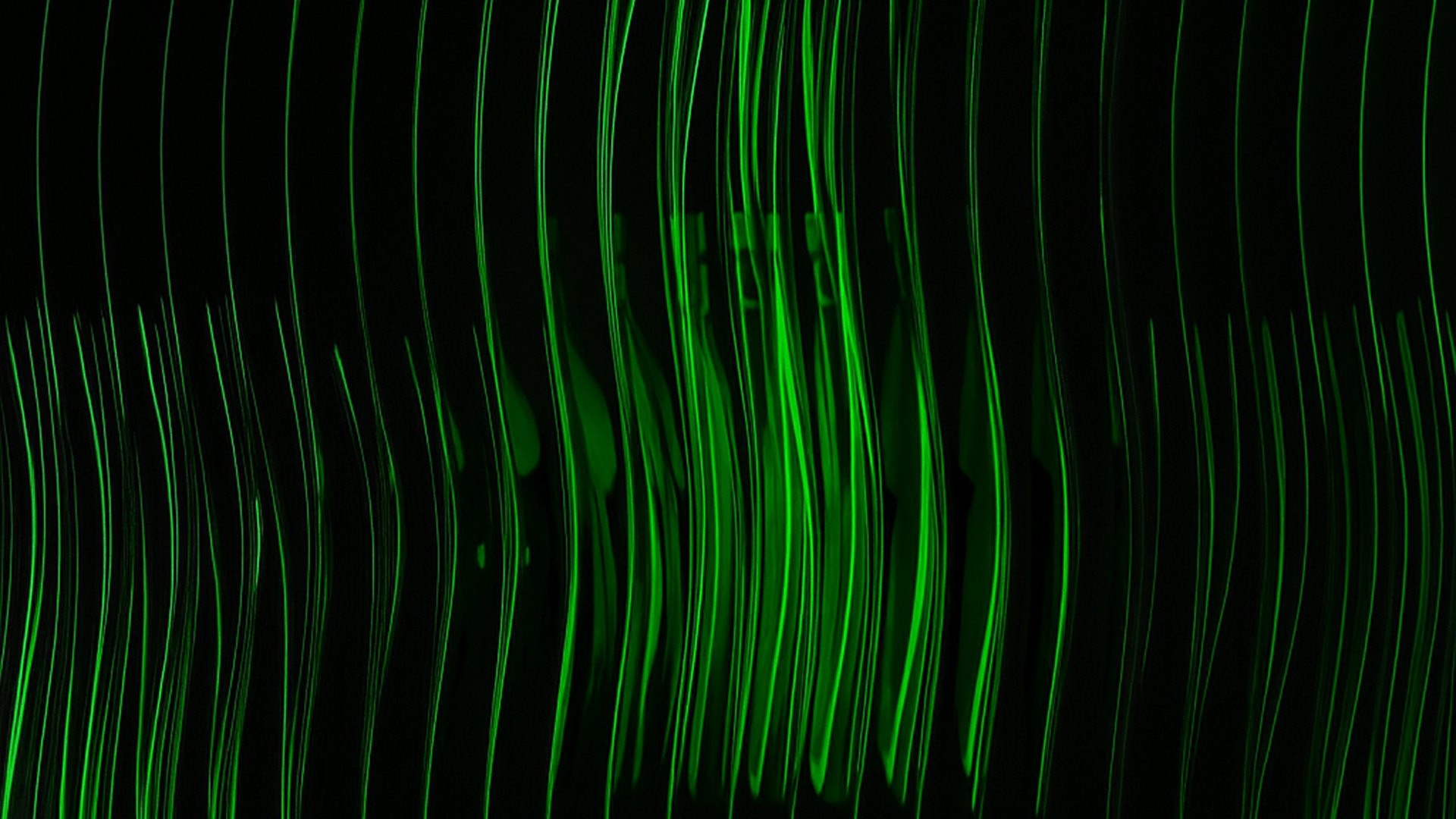 Abstract vertical green light streaks on a black background creating a wavy pattern.